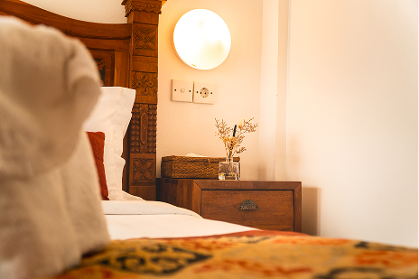 Bedside table with a lamp and fresh flowers in the Family Room