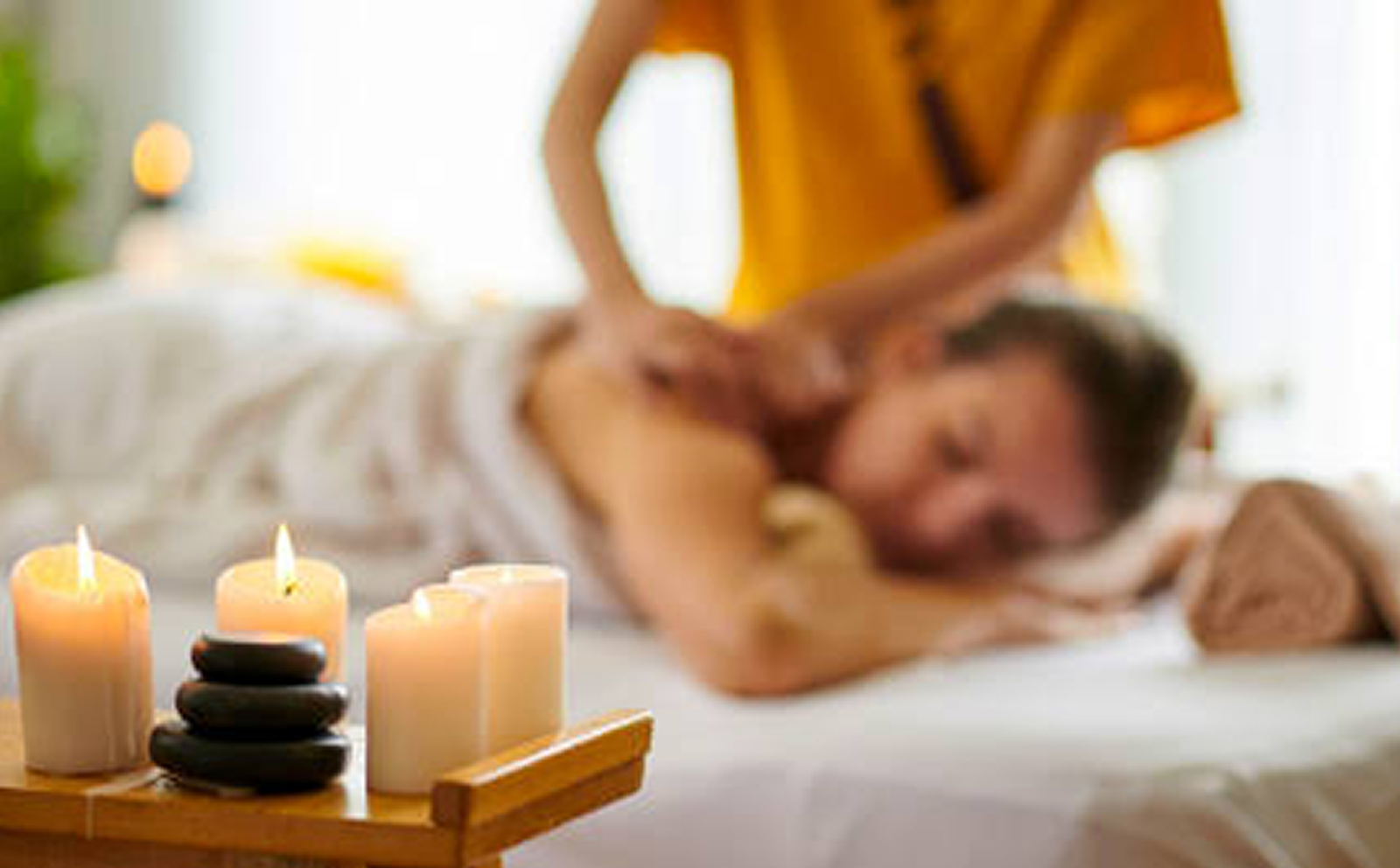 Candles and hot stones beside a spa massage treatment
